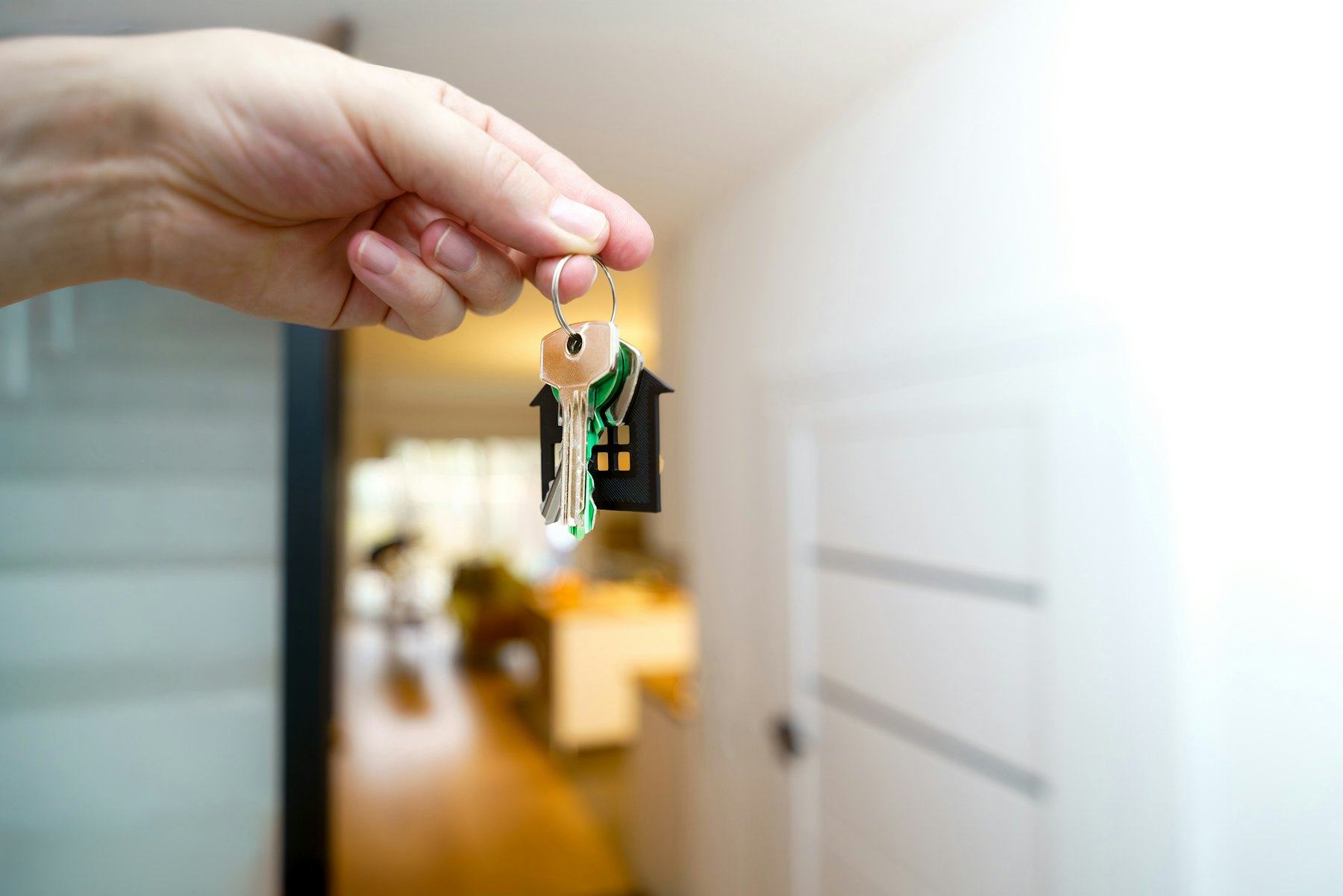 Une main tient les clés d'un logement