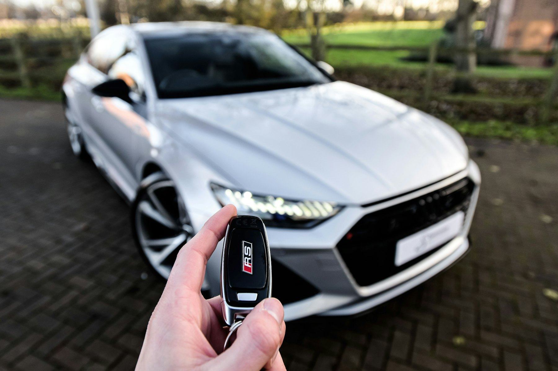 Une clé de voiture devant un véhicule